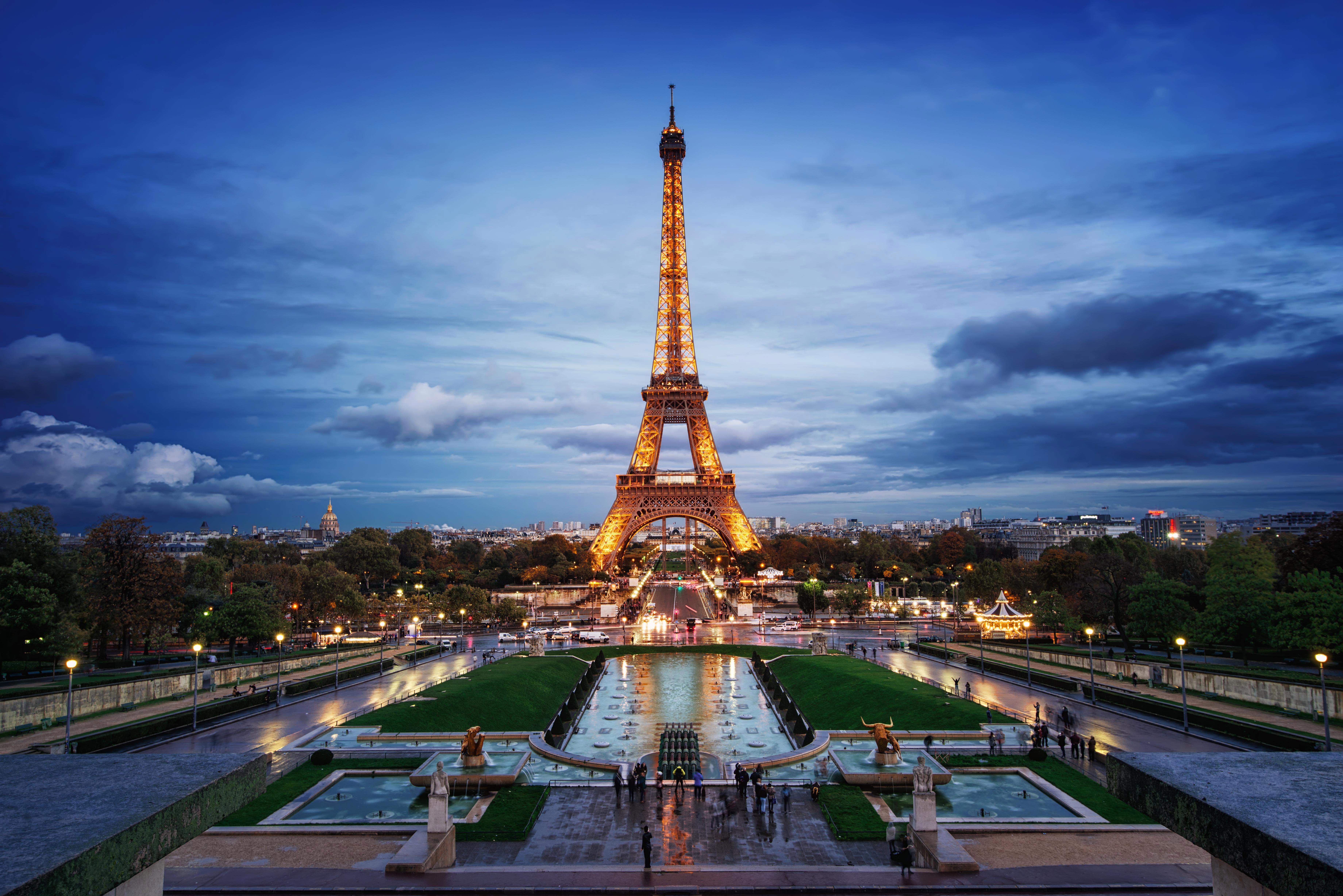 A lit up Eiffel Tower in Paris with a clear night sky behind it.